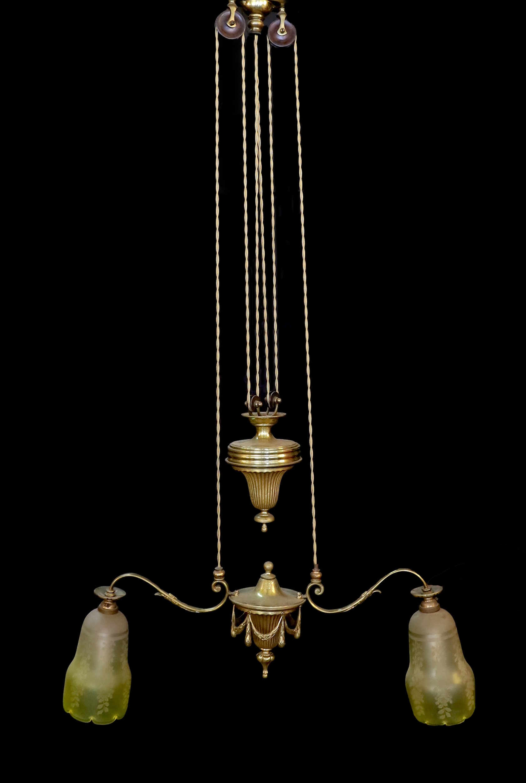 An early 20th century English ormolu counter balanced ceiling light with twin branches, swagged turn centre and yellow tinted frosted glass shades, height from 60 to 120cm